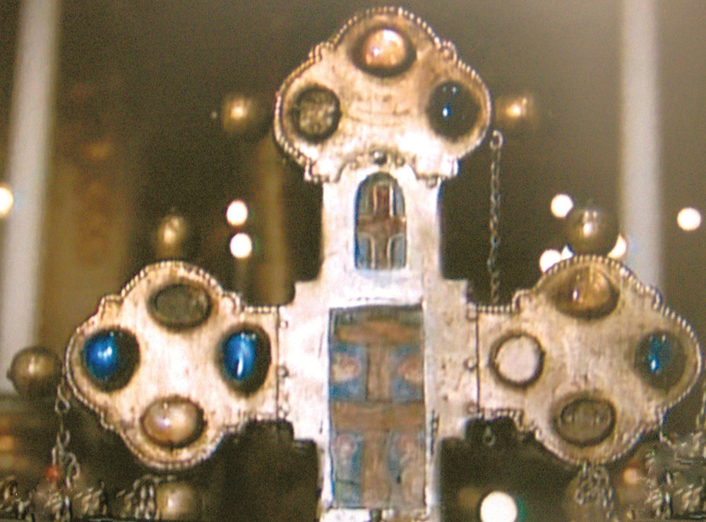 Enlarged image of the relic of the Host contained in a precious Cross, made by a Venetian craftsman (13th century) about to see and place inside the cross. Having taken the oath, the craftsman took the pyx contai-